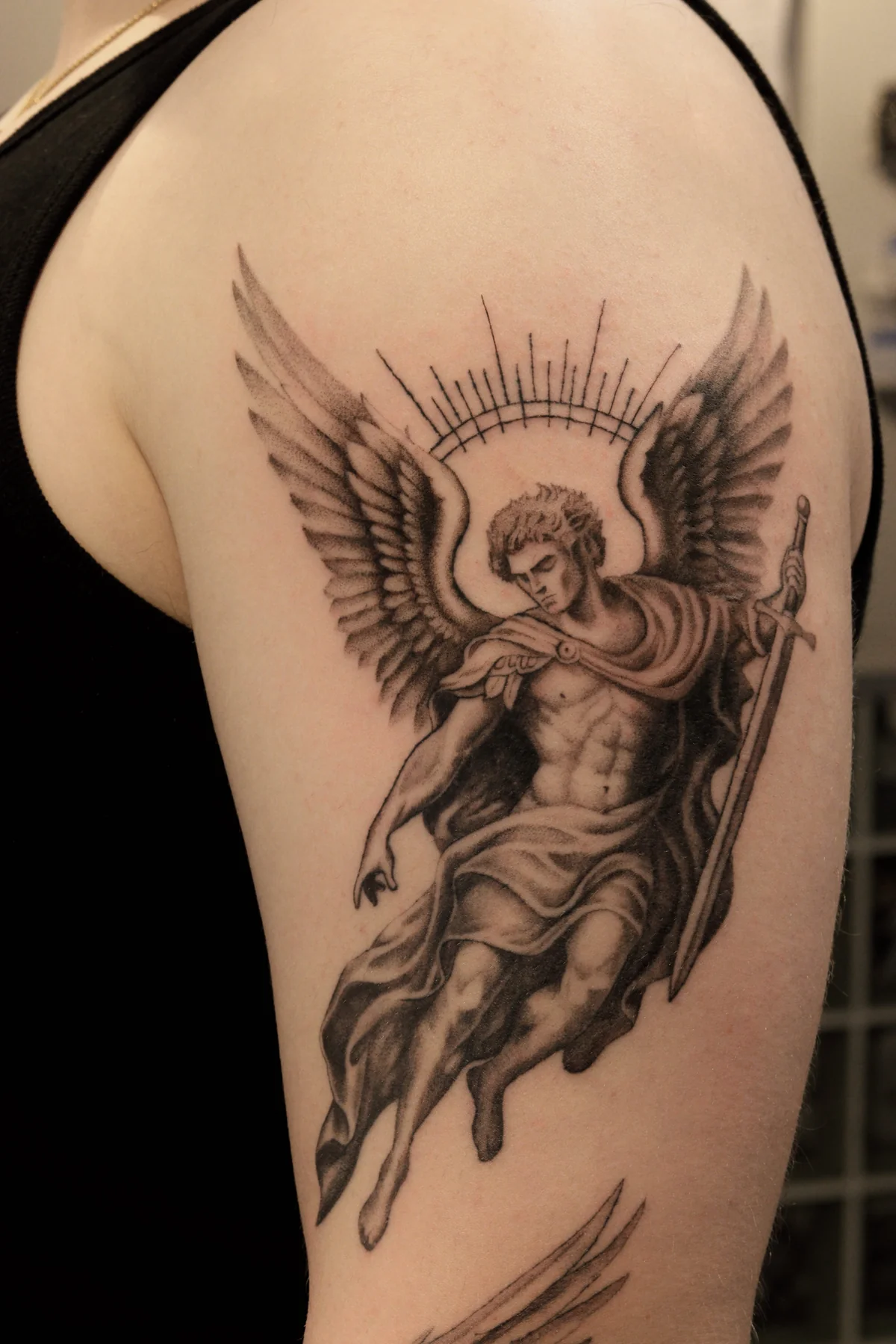 Close-up of Archangel Michael on the upper arm with feathered wings, radiant halo, sword and drapery, Prague by Andrey Kovalov