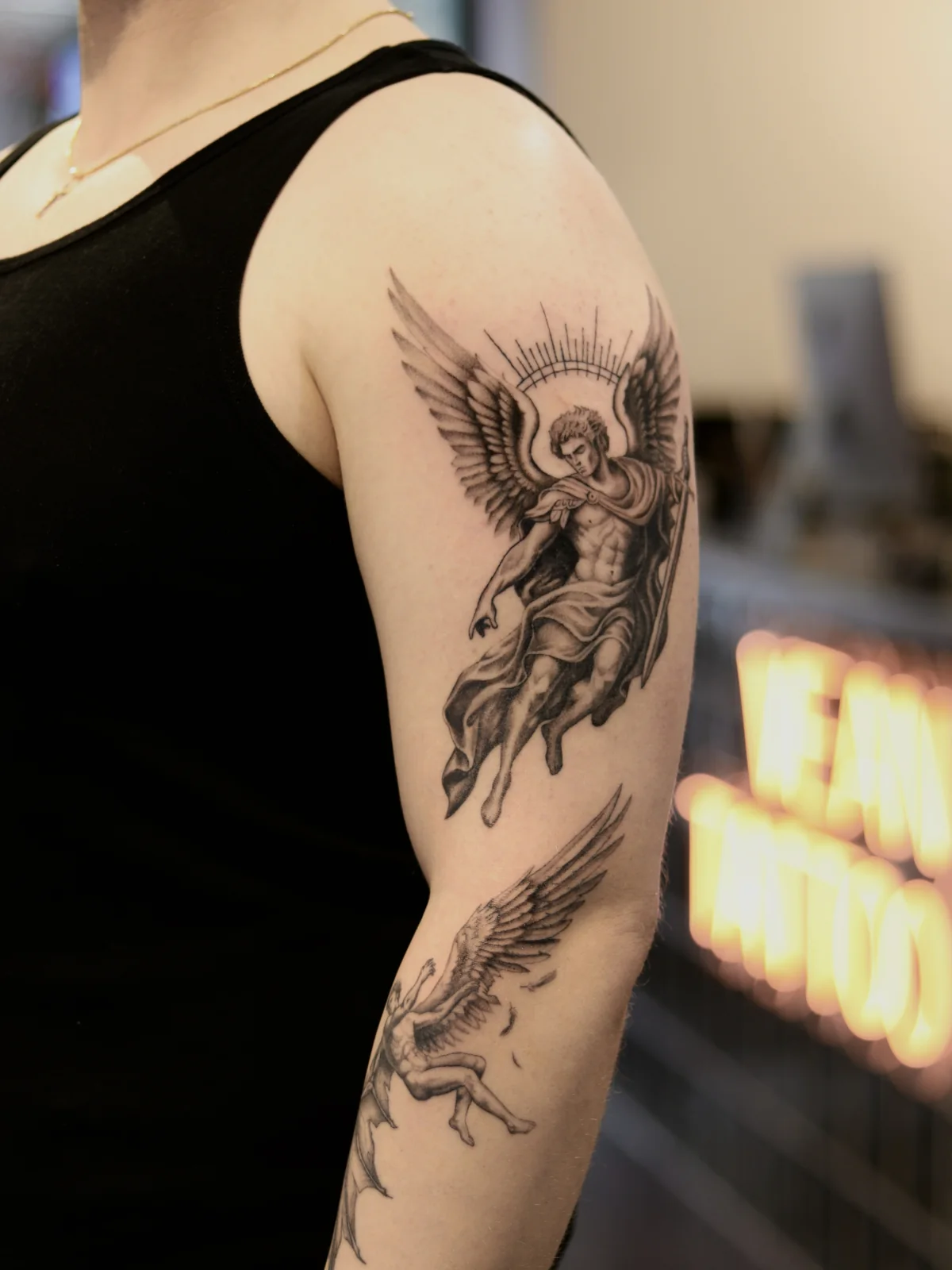 Connected black and grey arm composition with Archangel Michael on the upper arm and falling Lucifer on the forearm, Prague by Andrey Kovalov