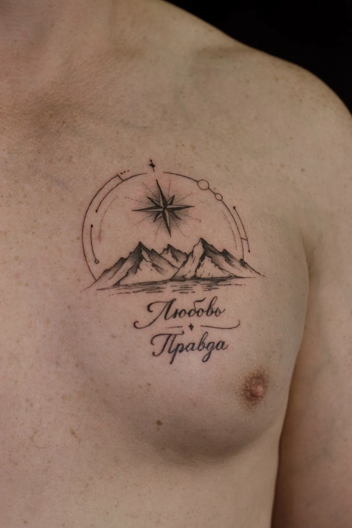 Fine line chest tattoo with mountain peaks, compass star, orbital geometry and Cyrillic words Love and Truth, Prague by Andrey Kovalov